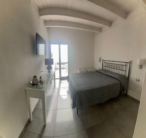 a bedroom with a bed and a table with a bed sidx sidx sidx at Hotel Boutique Il Castellino Relais in Vieste