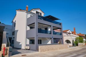 un edificio blanco con balcones en una calle en House Torre en Mali Lošinj