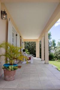 a porch of a house with benches and a plant at Sugarfields Garden Villa in Jolly Harbour