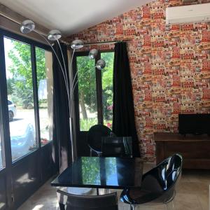 une salle à manger avec un mur en briques, une table et des chaises dans l'établissement charmant loft à la campagne, à Cavaillon