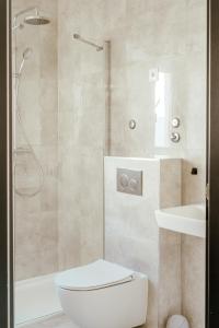 a bathroom with a shower and a toilet and a sink at Blue Marina Apartments in Marina