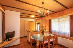 eine Küche und ein Esszimmer mit einem Tisch und einem TV in der Unterkunft Residenz Edelweiss SAAS310 in Saas-Balen
