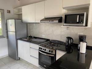 uma cozinha com um fogão, um micro-ondas e um frigorífico em Quinta Luna NH em San Carlos de Bariloche