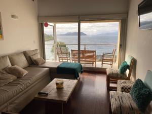 sala de estar con sofá y vistas al océano en Quinta Luna NH en San Carlos de Bariloche