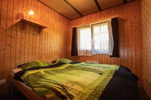 Łóżko w drewnianym pokoju z oknem w obiekcie Residenz Edelweiss SAAS320 w mieście Saas-Balen