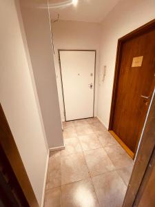 einen leeren Flur mit Tür und Fliesenboden in der Unterkunft Apartamenty KTW Dębowe Tarasy in Kattowitz