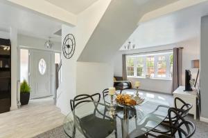 a dining room with a glass table and chairs at Bright & Spacious with Garden & Parking in Nottingham