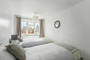 2 camas en una habitación blanca con ventana en Bright & Spacious with Garden & Parking en Nottingham