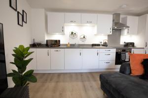 a kitchen with white cabinets and a couch in a room at The Courtyard in Southampton