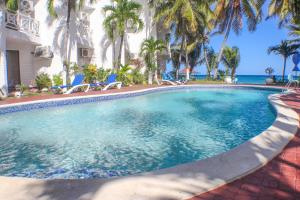 una grande piscina con palme e l'oceano di Chrisann's Hidden Cove-2 Bedroom a St Mary