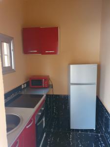 a kitchen with a white refrigerator and a sink at Appartement Meuble AU GOLF Bamako in Bamako