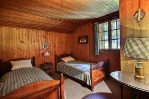 a bedroom with two beds and a table and a window at Chalet Nouchka VERB120 in Verbier