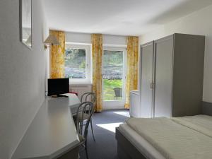 a hotel room with a bed and a desk with a computer at Hotel Belmont in Imst +36 photos