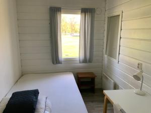 Habitación pequeña con cama y ventana en Poroholman Lomakeskus, en Rauma