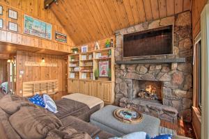 uma sala de estar com uma lareira de pedra e uma televisão em Serene Lakefront Escape Boat Dock and Grill! em Twin Lakes