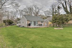 a home with a large yard with a house at Cape Cod Cottage with Fire Pit - Walk to Beach! in Brewster