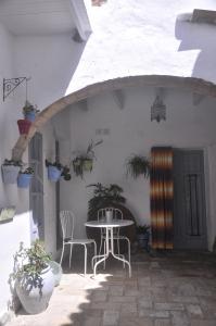 un patio con mesa, sillas y plantas en Vivienda Turística de Alojamiento Rural Cilla Vieja, en Vejer de la Frontera