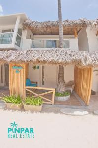 una casa en la playa con techo de paja en Villa Blanca Beach Club, en Punta Cana