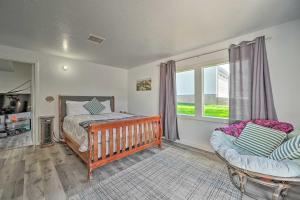 a bedroom with a crib and a bed and a chair at Stylish Basecamp 6850 Near Downtown Williams! in Williams