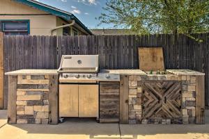 a outdoor kitchen with a stove and a fence at Patio, Grill and Yard Cozy Denver Abode! in Denver