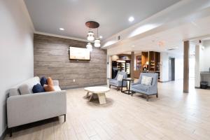 a lobby with couches and chairs and a tv at Candlewood Suites Houston Westchase - Westheimer, an IHG Hotel in Houston