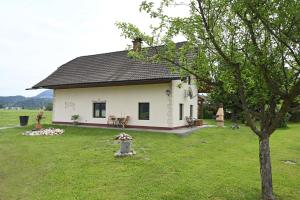 a small white house in a field with a tree at Haus Wilma in Dieschitz