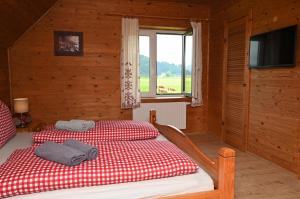 um quarto com uma cama com um cobertor xadrez vermelho e branco em Haus Wilma em Dieschitz