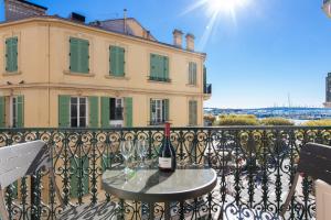 a bottle of wine sitting on a table on a balcony at Anzur YourHostHelper in Cannes