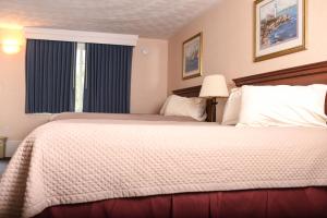 a bedroom with a large bed and a window at Ogunquit Hotel and Suites in Ogunquit