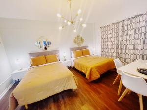 a bedroom with two beds and a table and chairs at Nine20 Collins Apartments by Lowkl in Miami Beach