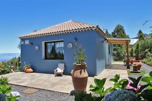 蓬塔戈爾達的住宿－Casa Rosales with Pool & Wifi，蓝色的房子,设有配有椅子的庭院