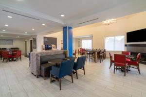 een lobby met tafels en stoelen en een restaurant bij Holiday Inn Express Hotel & Suites Bluffton at Hilton Head Area, an IHG Hotel in Bluffton