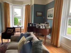 ein Wohnzimmer mit Sofa und Klavier in der Unterkunft Inver in Cobh