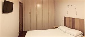 - une chambre avec un lit et une télévision murale dans l'établissement A estrenar!, à Bilbao