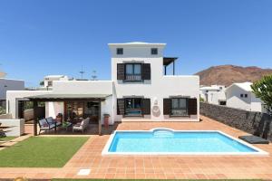 eine Villa mit einem Pool vor einem Haus in der Unterkunft Hipoclub Villas, Aguamarina 10 in Playa Blanca