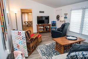 sala de estar con sofá, sillas y TV en Beadle Island Bungalow - Private Beach Access, en Caseville
