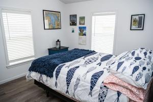 1 dormitorio con 1 cama y 2 ventanas en Beadle Island Bungalow - Private Beach Access, en Caseville