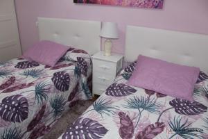 1 dormitorio con 2 camas individuales y mesita de noche en VUT La Fuentina -Casas de los Picos en Panes
