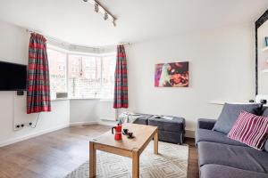 a living room with a couch and a table at Bright and stylish apartment in trendy Islington by UnderTheDoormat in London