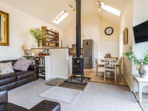 a living room with a couch and a wood stove at Brook Cottage in Stearsby
