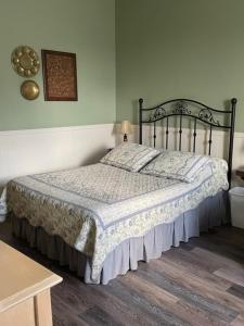 a bedroom with a bed with a blanket on it at Auberge Presbytere Mont Lac-Vert in Hébertville