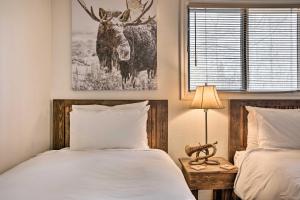 1 dormitorio con 2 camas y una foto de un ciervo en Skiers Dream Upscale Condo By Teton Village! en Wilson