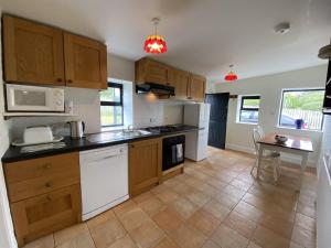 a kitchen with white appliances and a table in it at Cottage 426 - Moyard in Moyard