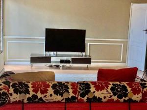 a living room with a couch and a flat screen tv at Beautiful apartment in century city in Cape Town