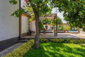 a tree in a yard with a swing at Vila Rosen in Lozenets