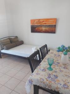 a room with a table and a bed and a table and chairs at Kostas Apartments in Ierissos