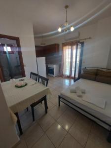 a living room with a table and a bed and a kitchen at Kostas Apartments in Ierissos