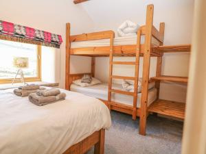 a bedroom with two bunk beds and a window at Columbine Barn in Bradwell