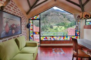 sala de estar con sofá, mesa y ventana en Suites Arcoiris, en Villa de Leyva