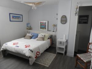 a bedroom with a bed and a chair at les volets bleus in Saint-Guénolé